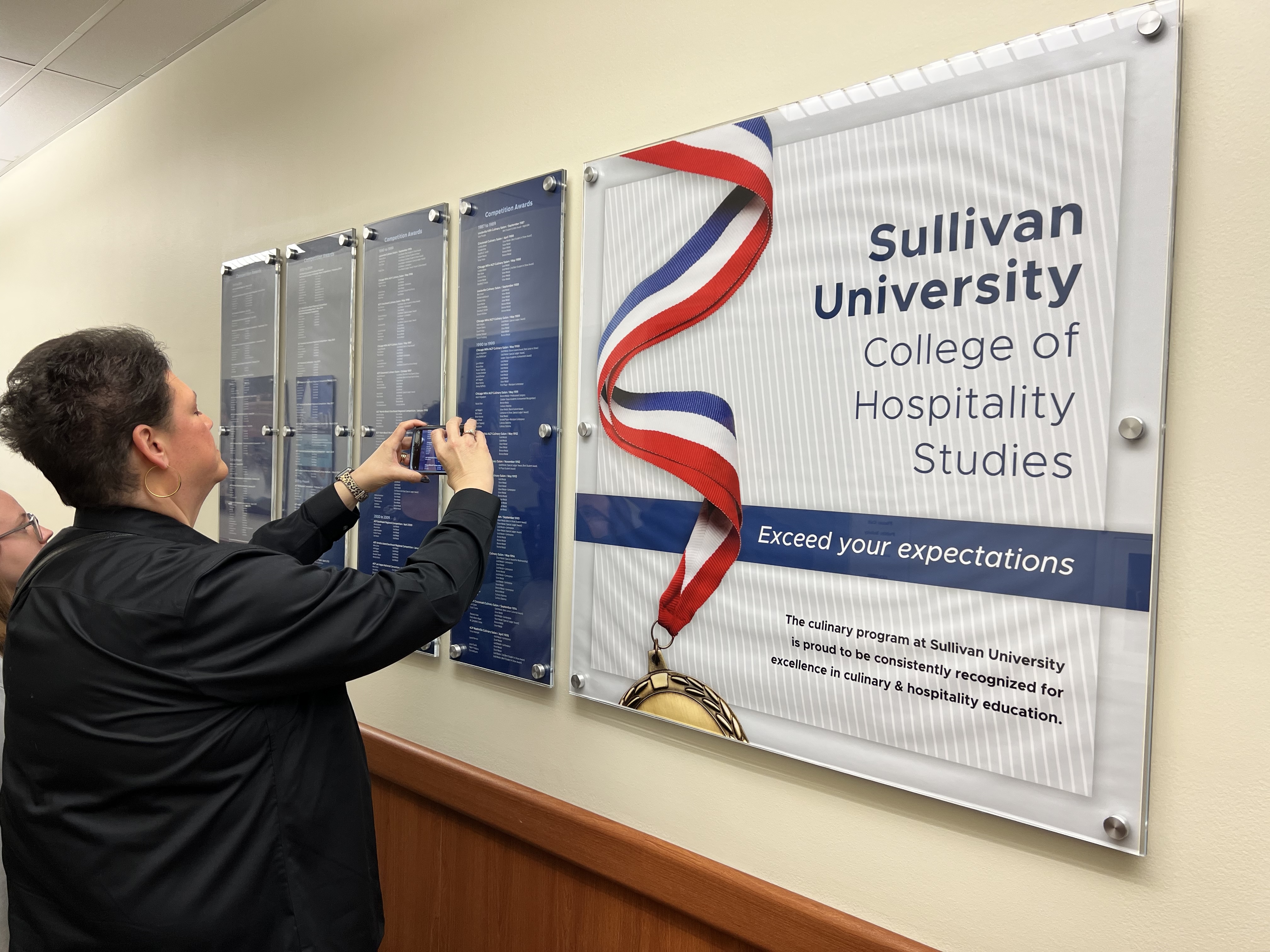 Sullivan University College of Hospitality Studies competition awards wall — David Bailey's name listed under Chicago NRA/ACF Culinary Salon, May 1992